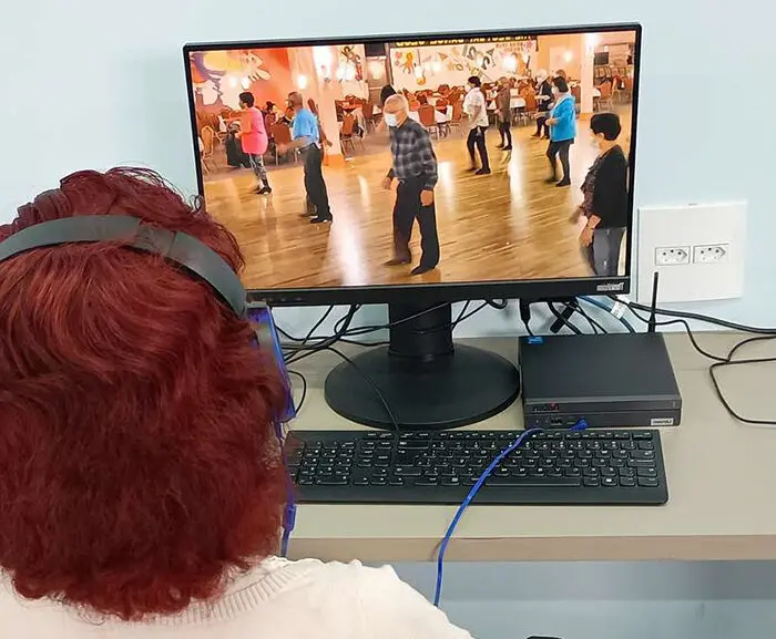Idosa aprendendo a usar tecnologia digital.