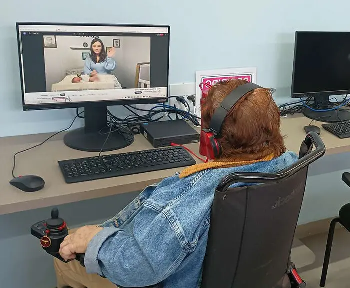 Idosa assistindo vídeo no computador.