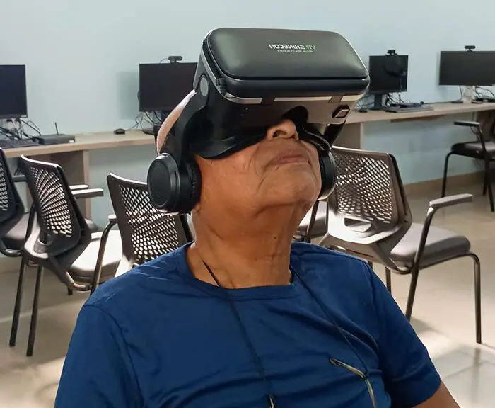 Idoso experimenta óculos de realidade virtual, atividade promovida no projeto Conexão 60+ para estimular novas experiências tecnológicas.